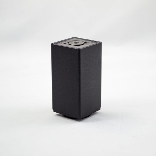 A black cube sitting on a white surface.