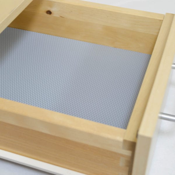 A wooden drawer with PRISMA DESIGN sheets for non-slip usage.