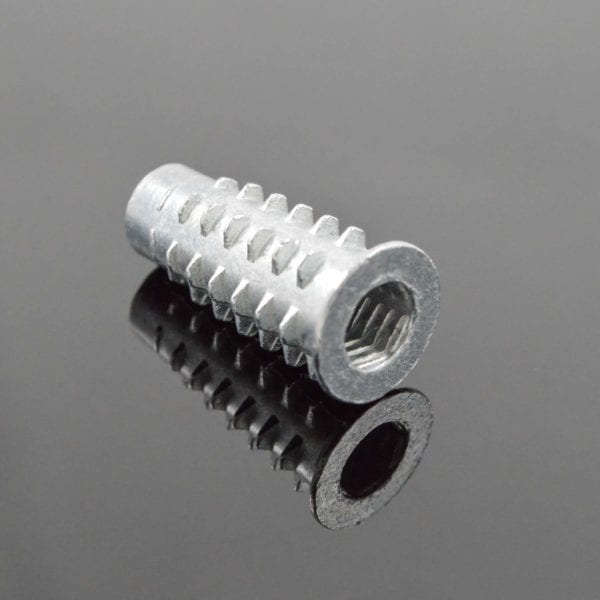 A stainless steel nut on a black surface.