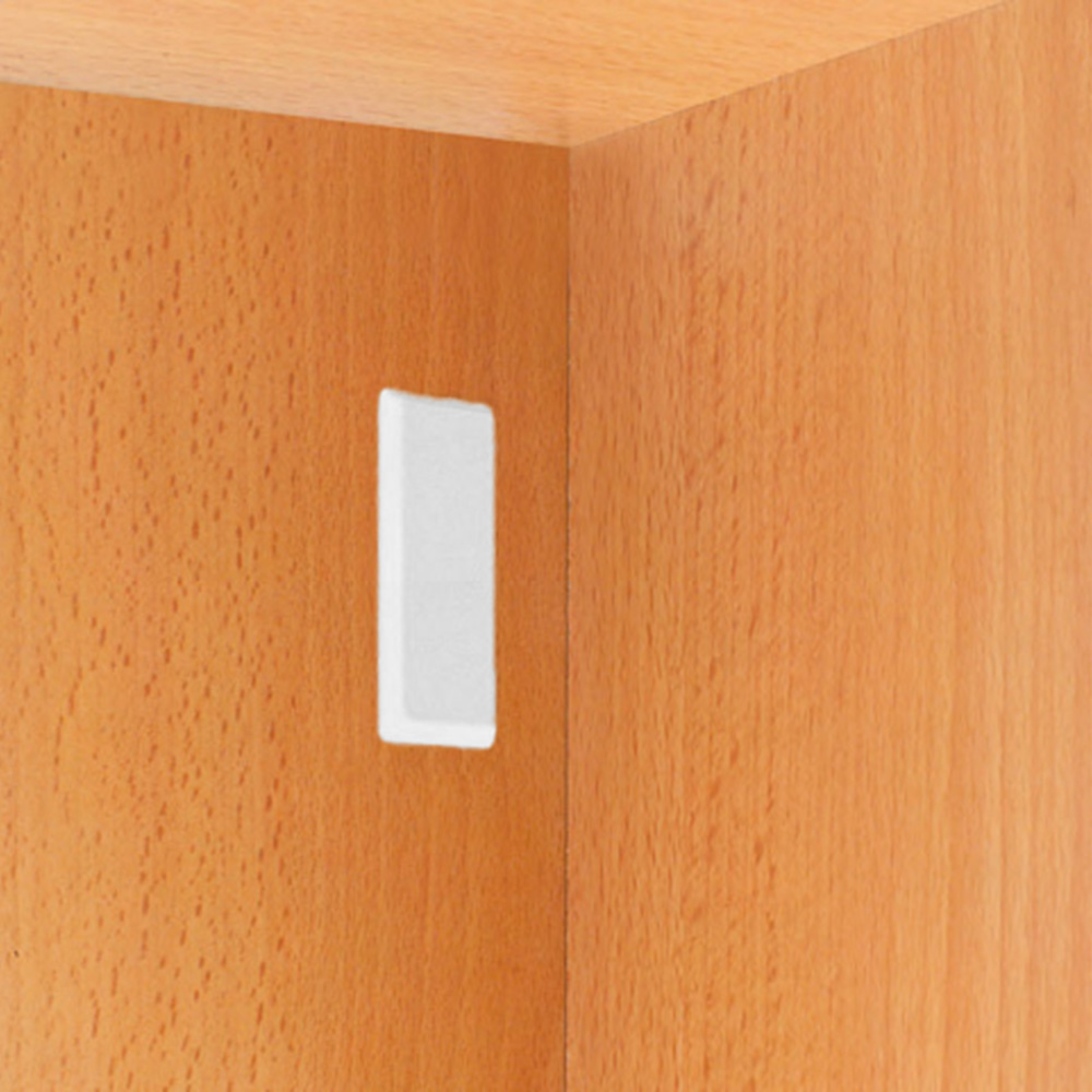 A white button on a wooden cabinet.