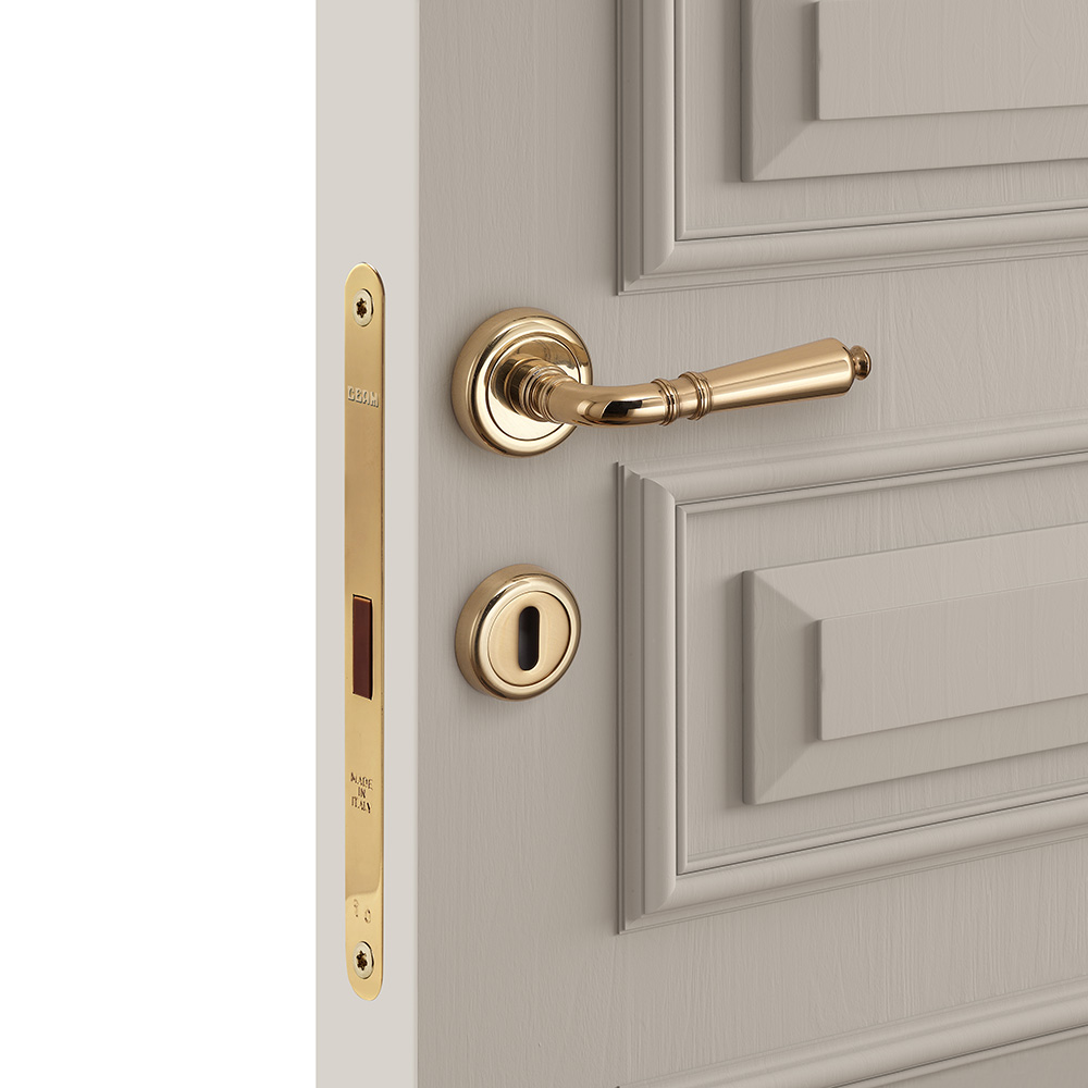Gold european door lock mounted on a white door