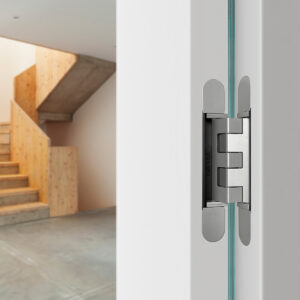 Concealed hinge installed in white open door with stairs on the background